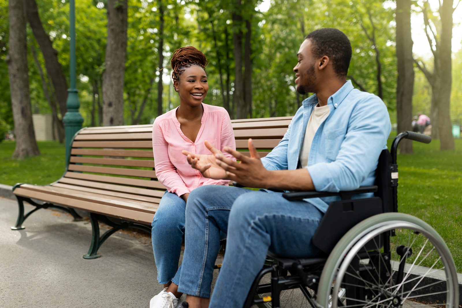 Two people talking together on a park bench