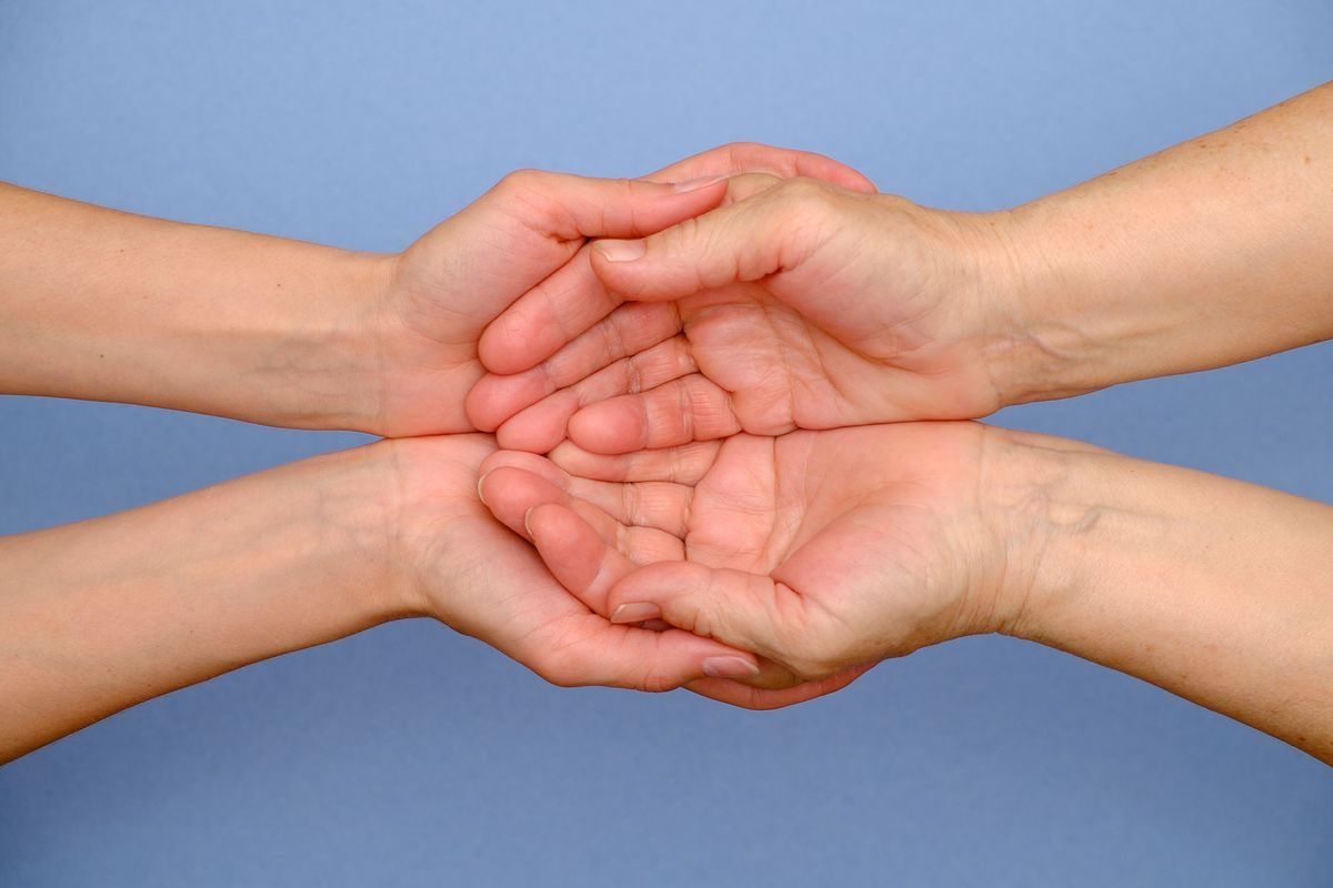 Two pairs of hands held together